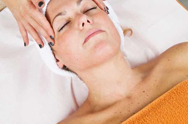 Mulher bonita recebendo massagem facial com olhos fechados
 - Foto, Imagem