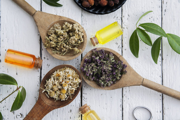 Dry herbs and essences on the wooden table. Alternative medicine. Flat lay - Фото, зображення