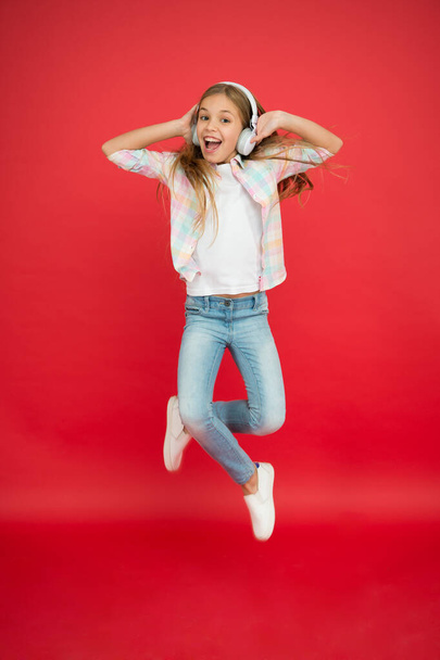 I believe i can fly. Girl listening music modern gadget. Kid happy with wireless headset dancing jumping. Stereo headphones. Kid using modern technology. Modern child. Perfect sound. Never ending joy - Foto, Imagem