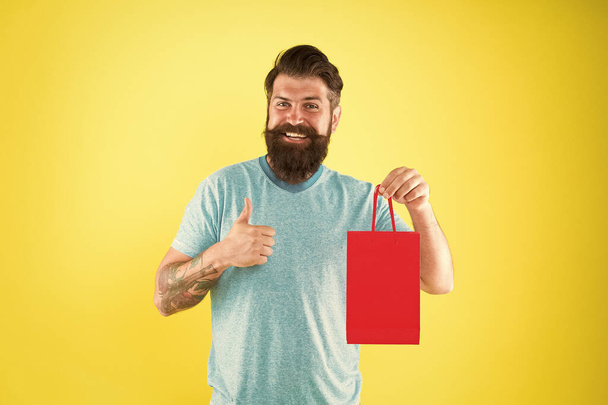 pleasant prices here. cyber monday concept. little pleasantness. bearded man go shopping. store for men. mature male beard with purchase. happy hipster hold red paperbag. best offer. Man with package - Foto, Imagen