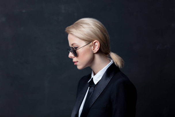 Style επιχειρηματίας σε ένα κλασικό μαύρο κοστούμι επιχειρήσεων και γυαλιά ηλίου - Φωτογραφία, εικόνα