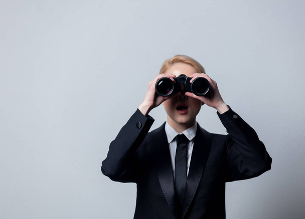 Style businesswoman in a classic black business suit with binoculars  - Photo, Image