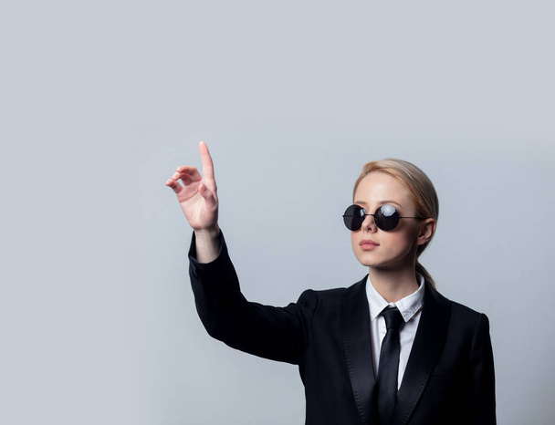 Femme d'affaires de style dans un costume d'affaires noir classique et des lunettes de soleil
 - Photo, image