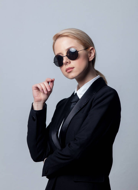 Bizneswoman w klasycznym czarnym garniturze biznesowym i okularach przeciwsłonecznych - Zdjęcie, obraz