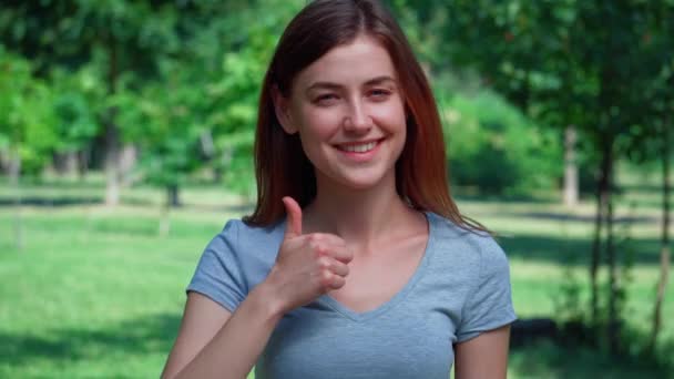 portré vidám női mutatja hüvelykujj fel a szabadban - Felvétel, videó