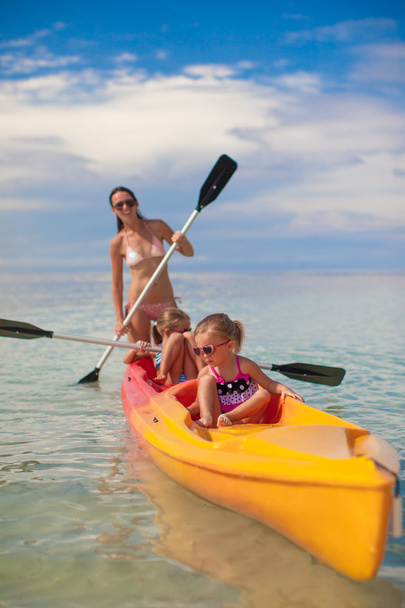 dwa mały dziewczyna i młoda matka kajak na ciepłe morze - Zdjęcie, obraz