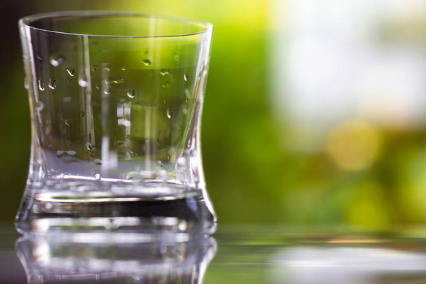 gouttes d'eau de verre transparent sur la texture de réflexion dans le fond de jardin vert bokeh, Gros plan & Macro shot, Mise au point sélective, concept de boisson saine
 - Photo, image