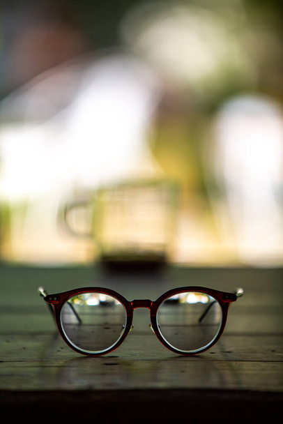 Eyeglasses, Coffee glasses cup with coffee stains stuck on them, then after drinking it on wooden table in bokeh blurred green garden background, Close up shot, Selective focus - Photo, Image