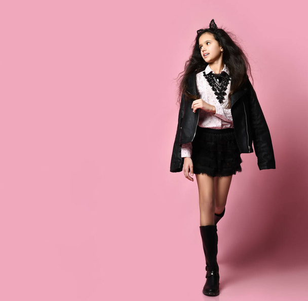 Teenager in white blouse, black jacket and boots, headband like cat ears. Posing on pink background. Copy space. Full length - Photo, image