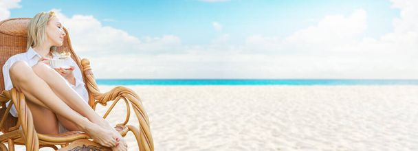 Young beautiful blonde woman enjoying tropical sea view while sitting on chair at luxury resort lounge. Wide web banner format design - Fotoğraf, Görsel