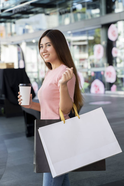 Young female holding two bag, mockup blank screen paper shopping bag with clipping path, Empty space on shopping bag for design insert logo or graphic. - Foto, Bild