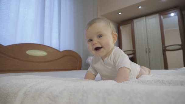 Leuke baby met blauwe ogen liggend op het bed - Video