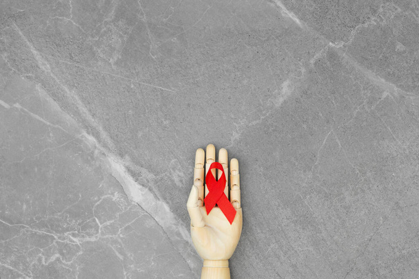 Wooden hand with HIV red ribbon - Photo, Image
