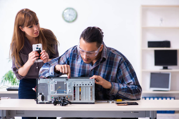 Два техника, работающие в компьютерном гарантийном центре - Фото, изображение