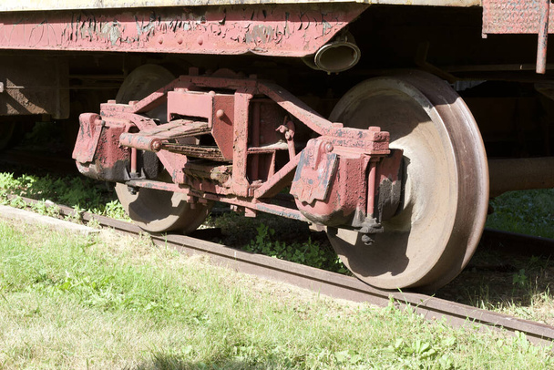 Κοντινό πλάνο δείτε τους τροχούς σε ένα παλιό σιδηροδρομικό βαγόνι με ξεπερασμένη και φθαρμένη εμφάνιση - Φωτογραφία, εικόνα