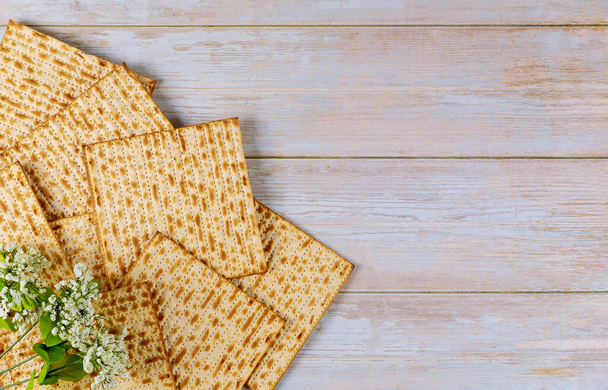 Background of matzah bread with white flowers. Jewish Passover holiday concept. - Photo, Image