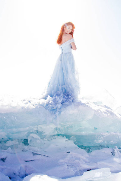 girl in a long evening dress stands on the ice of Lake Baikal - Фото, изображение