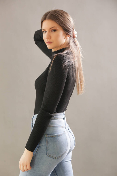 Portrait of young brunette in black turtleneck. Studio shot of young beautiful woman. - Photo, Image