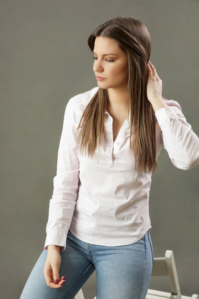 Krásný portrét mladé brunetky v klasické bílé košili. Studio záběr mladé krásné ženy. - Fotografie, Obrázek