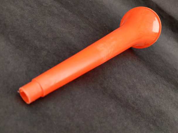 Blanke Vuvuzela-Stadionplastikhupe. Fan-Vuvuzela-Trompete isoliert auf schwarzem Hintergrund - Foto, Bild