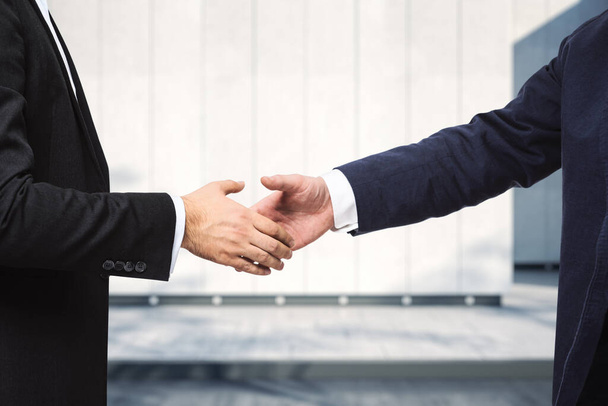 Handshake of two businessmen on the background of sunny exterior of the business center, signing of a contract concept, close up - Φωτογραφία, εικόνα