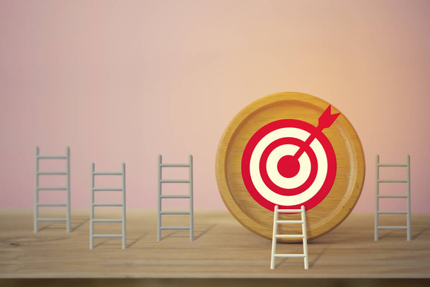 Goals concept: Longest white ladder and aiming high to goal target among other short ladders, depicts excellent performance and stands out from the crowd and thinks differently. - Photo, Image