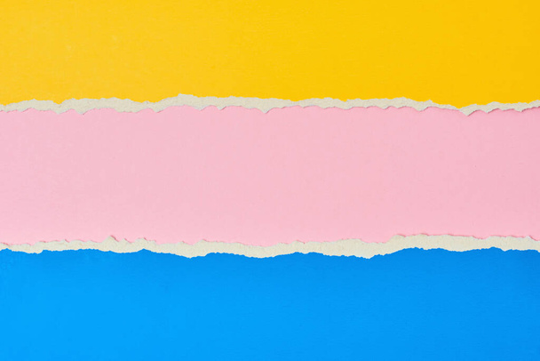 Borde de papel rasgado con espacio para copiar, fondo de color rosa, amarillo y azul
 - Foto, imagen