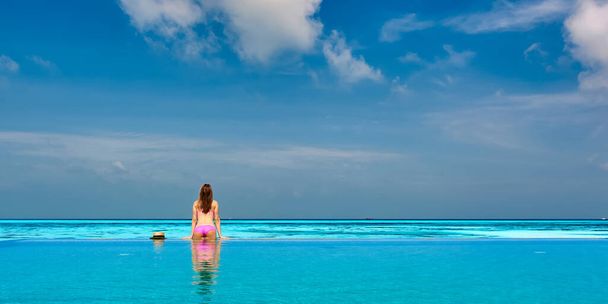 Donna rilassante nella piscina a sfioro alle Maldive
 - Foto, immagini