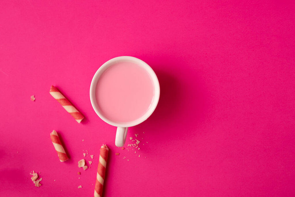 Cup of strawberry milk on pink background. - 写真・画像
