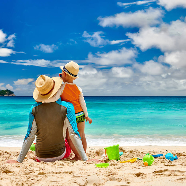 Trzyletni chłopiec na plaży z ojcem. Letni wypoczynek rodzinny na Seszelach, Mahe. - Zdjęcie, obraz