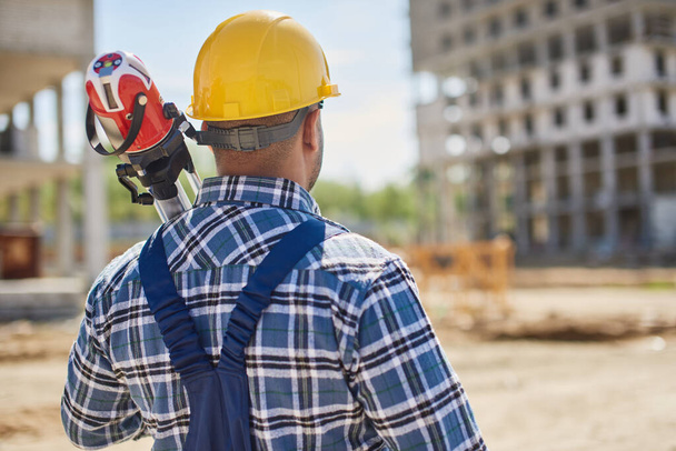 An engineer on the construction point holds work related equipment. - Φωτογραφία, εικόνα