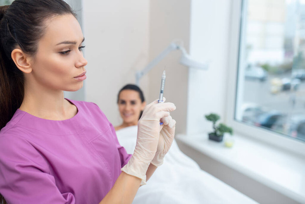 Cosmetologist taking syringe before making beauty injection - Foto, Imagen