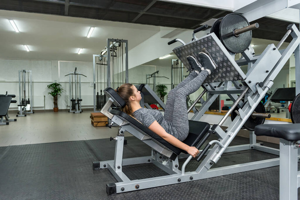 Woman is working on quadriceps in the gym - Photo, Image