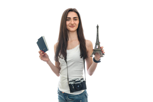 Mujer con cámara y pasaportes sosteniendo torre eiffel
 - Foto, imagen