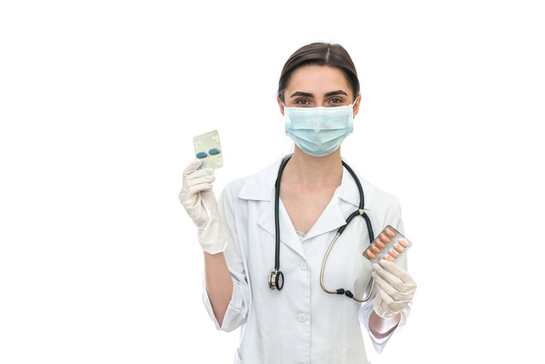 Médico con máscara sosteniendo pastillas en blister aislado en blanco
 - Foto, Imagen