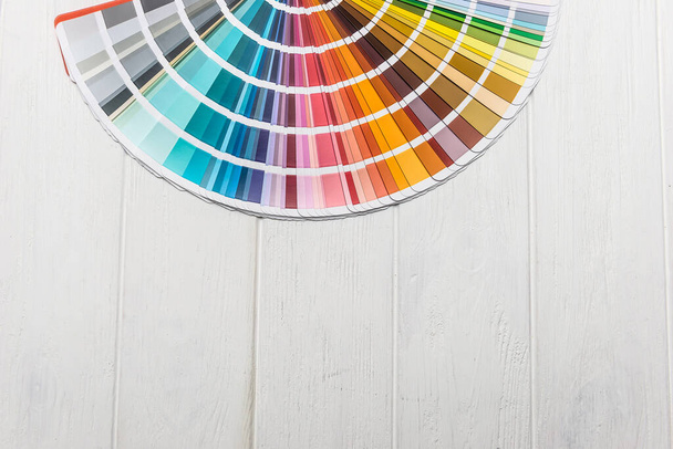 Kolorowa paleta do malowania ścian na drewnianym biurku - Zdjęcie, obraz