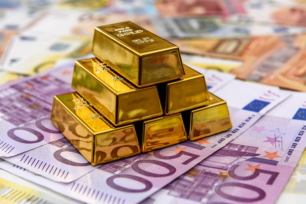 Piramide van goudstaven op de achtergrond van eurobankbiljetten - Foto, afbeelding