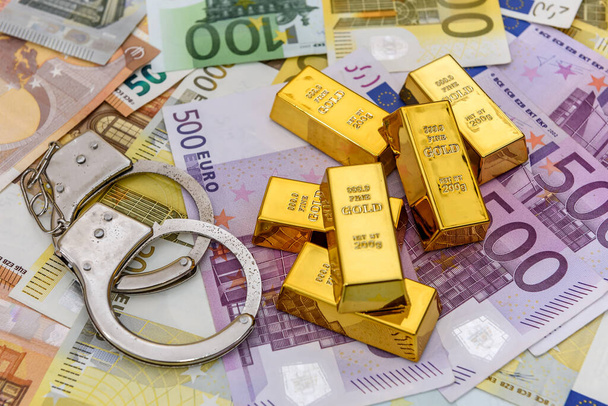 Gold bullions with handcuffs at euro banknotes background - Photo, Image