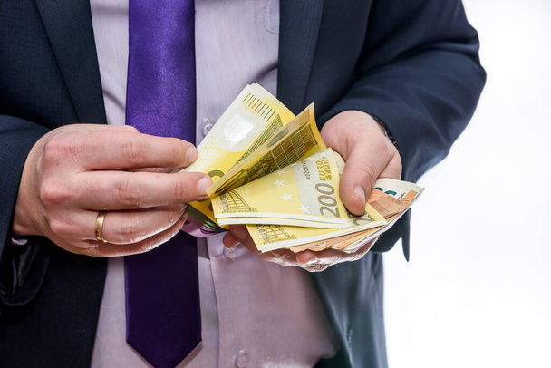 Uomo in giacca e cravatta che conta le banconote in euro da vicino
 - Foto, immagini
