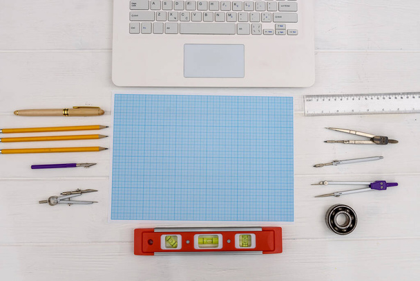 Konstruktionsausrüstung zum Zeichnen auf Millimeterpapier mit Laptop - Foto, Bild