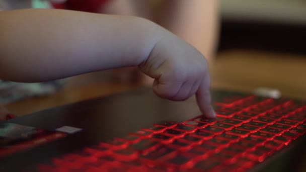 Küçük çocuk dizüstü bilgisayarında yazarken eğleniyor. Annesi yanına oturur ve güler. Zaman zaman çocuk çok şaşırır ve parmağıyla ekranı gösterir.. - Video, Çekim