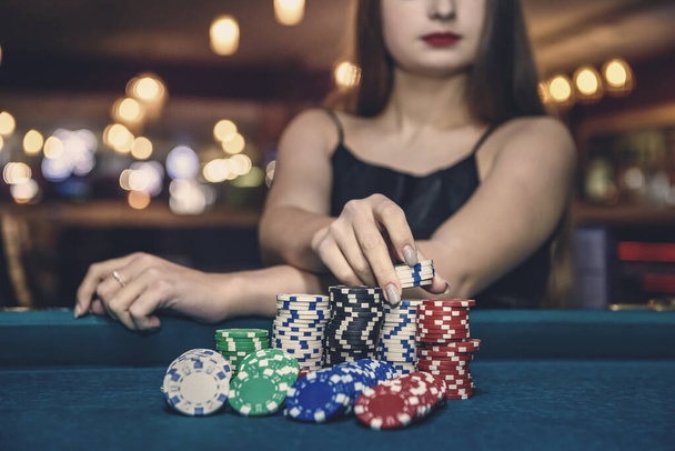 Main féminine prenant des jetons de poker de pile
 - Photo, image