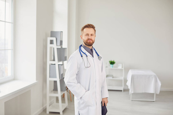 Male doctor pediatrician standing in the white office of the hospital. - Valokuva, kuva