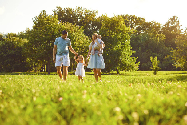 Happy family with children in the park at sunset. - 写真・画像