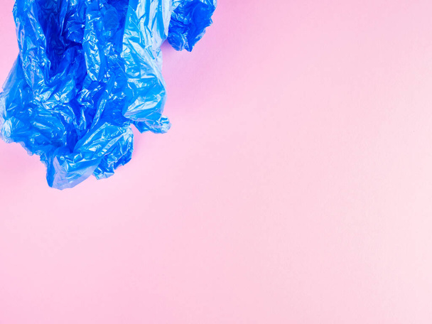 Bolso de basura de plástico azul arrugado sobre fondo rosa
 - Foto, imagen