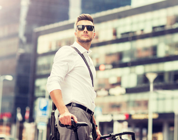 young man with bicycle on city street - Foto, Imagen