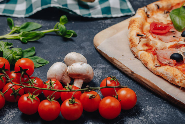 delicious Neapolitan pizza on a blackboard with cherry tomatoes, free space for text - Photo, Image
