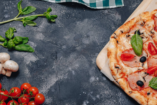 herkullinen napolilainen pizza liitutaulussa kirsikkatomaateilla, vapaata tilaa tekstille
 - Valokuva, kuva