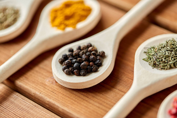 spoons with different spices on wooden table - 写真・画像