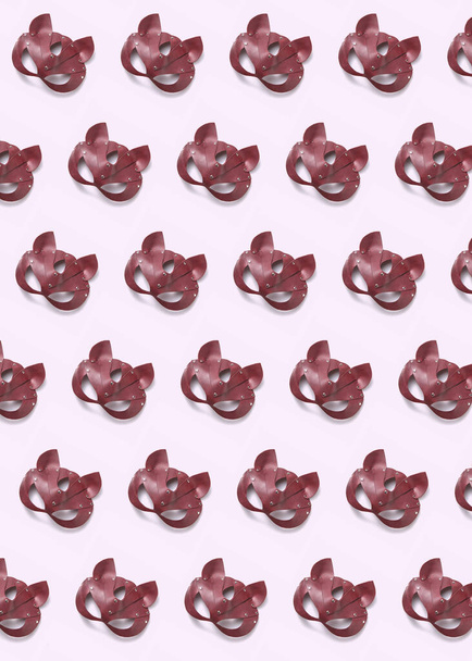 Erotic BDSM red leather cat mask pattern on a light pink background with soft shadows. Flat lay. Sex and erotic games concept. - Φωτογραφία, εικόνα